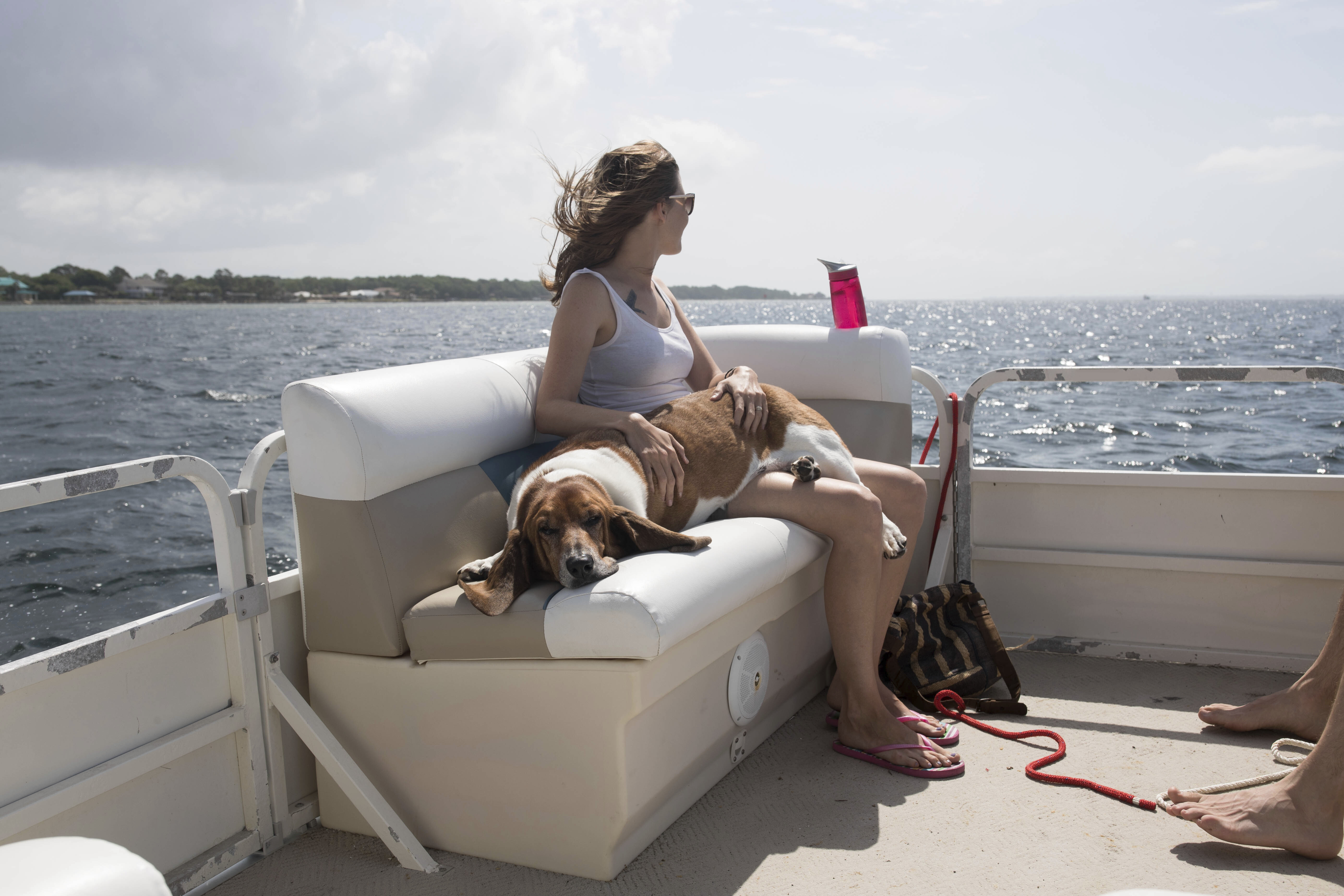 Woman relaxing on a pontoon boat with a dog during a Lake of the Ozarks boat rental day